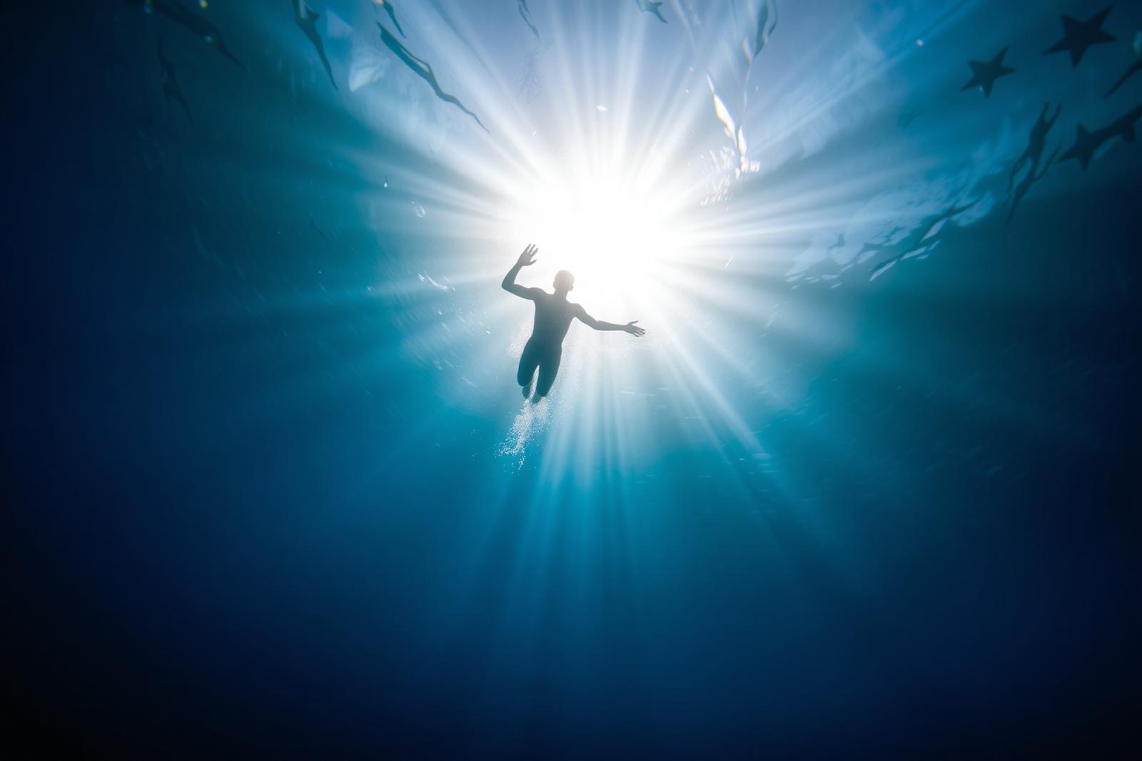 Underwater silhouette of swimmer